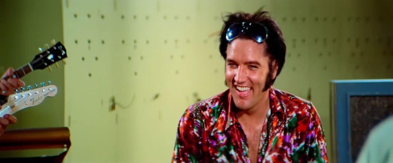 Elvis Presley laughing in a brightly coloured shirt in Epic: Elvis Presley in Concert