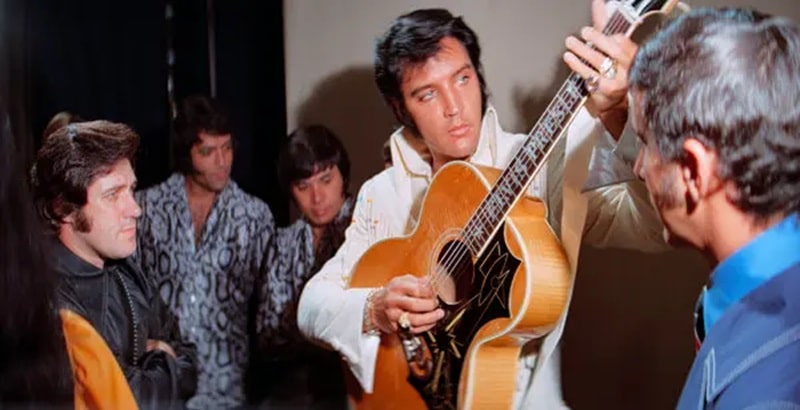 Elvis tuning up his guitar backstage in Epic: Elvis Presley in Concert